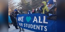 Protesters marching with banner